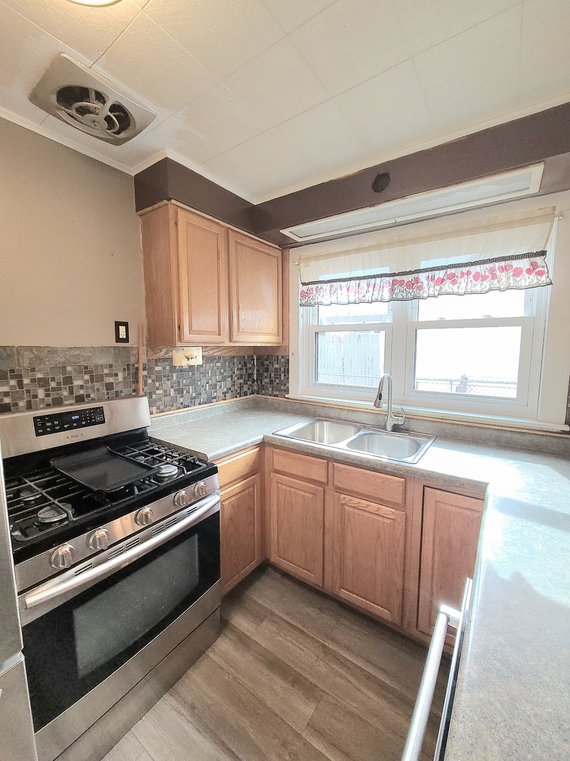 7807 Parkside Avenue Burbank, IL 60459 - Photo 4 of 23 a kitchen with stainless steel appliances granite countertop a stove and a sink