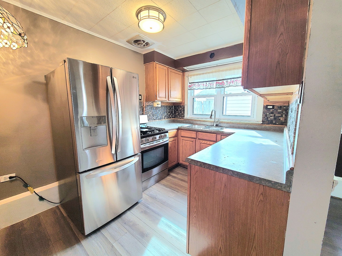 7807 Parkside Avenue Burbank, IL 60459 - Photo 5 of 23 a kitchen with stainless steel appliances granite countertop a refrigerator a sink dishwasher a stove and white countertops with wooden floor