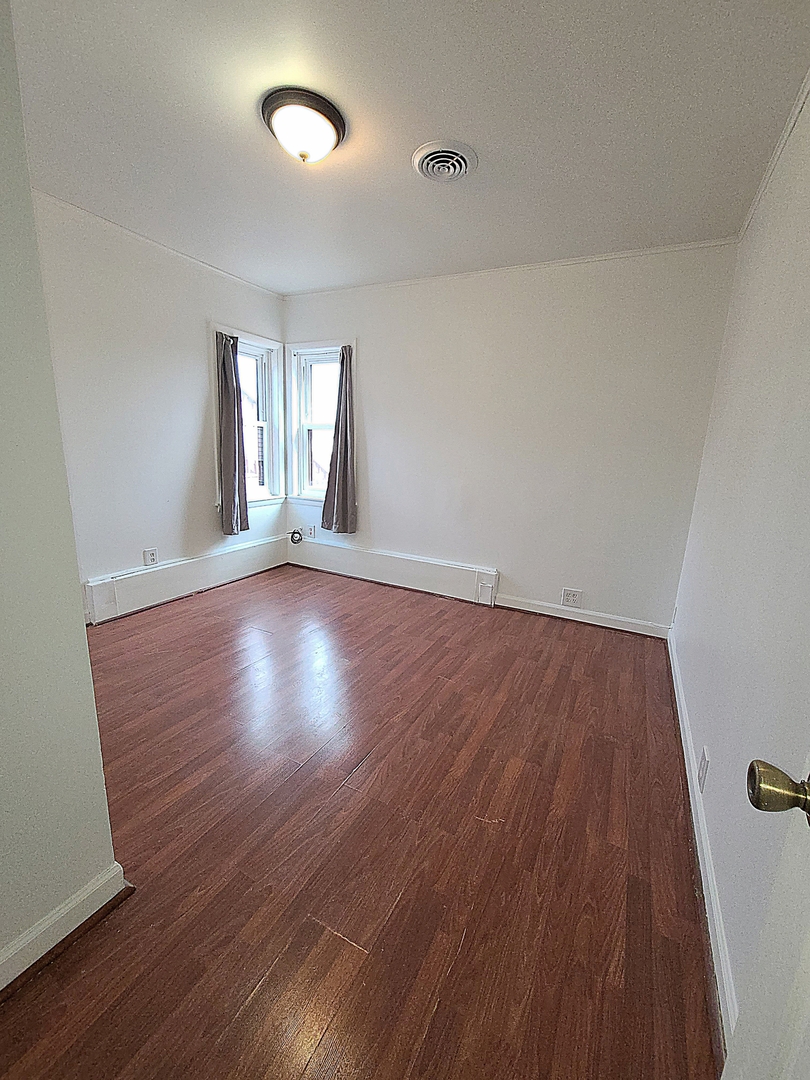 7807 Parkside Avenue Burbank, IL 60459 - Photo 10 of 23 wooden floor in an empty room with a window