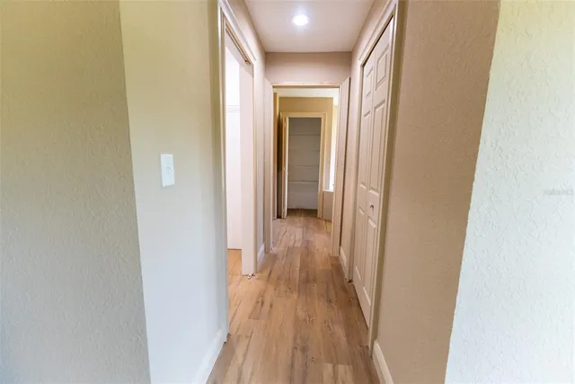 a view of a hallway with wooden floor and staircase
