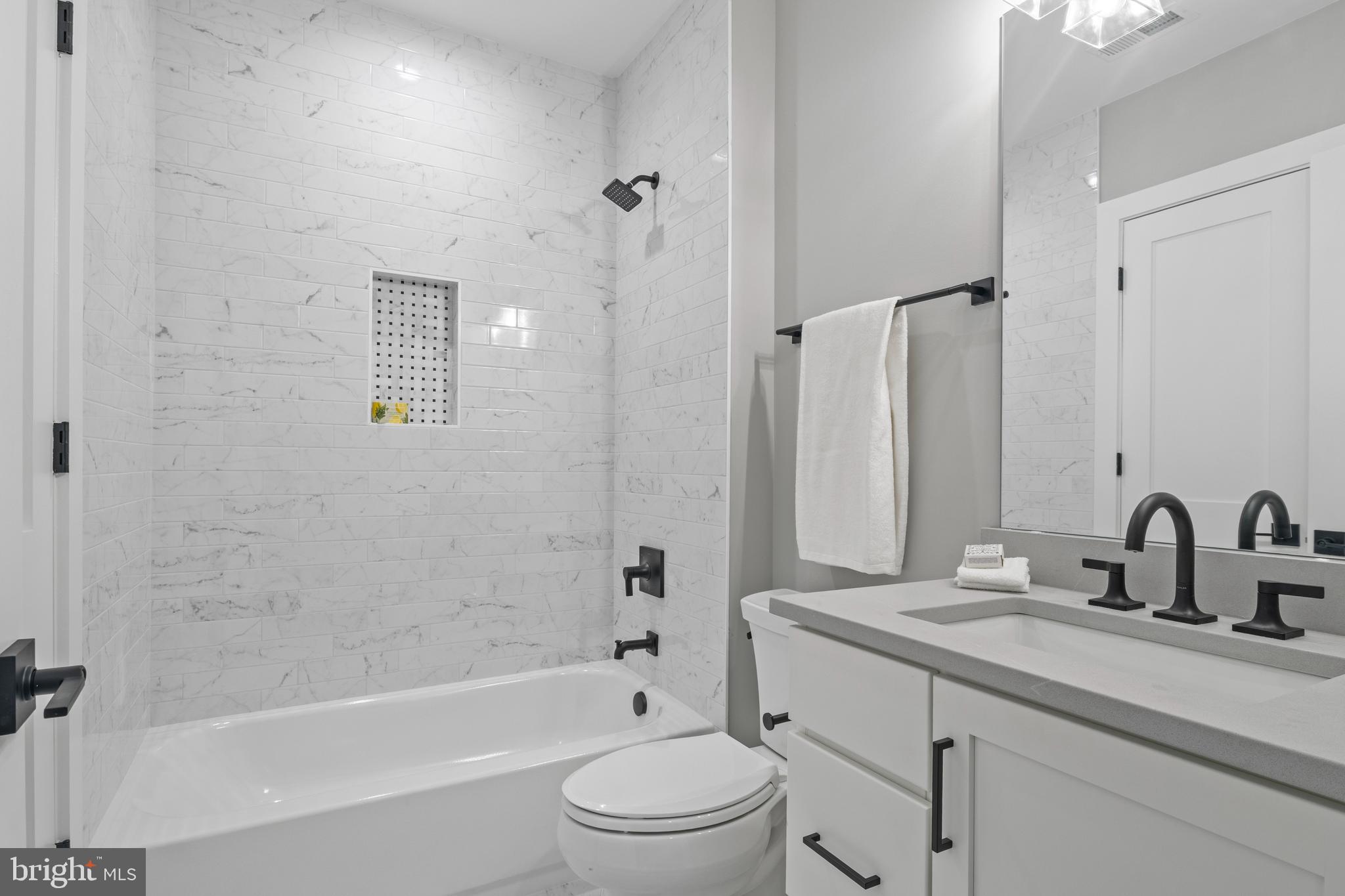 5912 Kingswood Road Bethesda, MD 20814 - Photo 13 of 13 a bathroom with a granite countertop sink a toilet and a bathtub