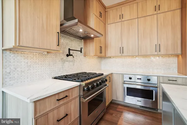 a kitchen with stainless steel appliances granite countertop a stove and a white cabinets