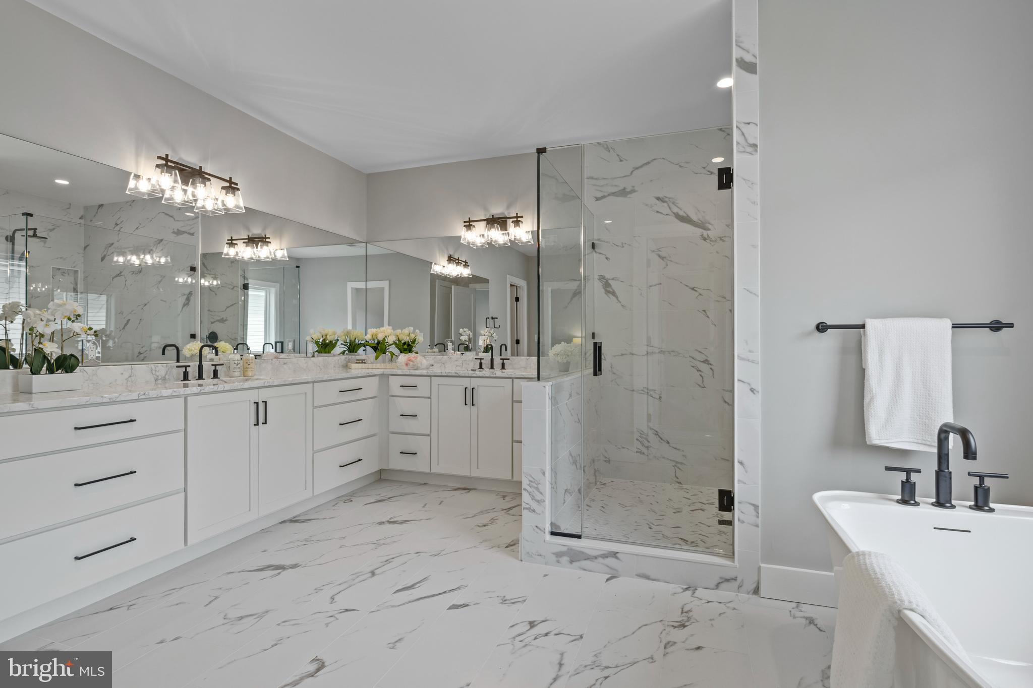 5912 Kingswood Road Bethesda, MD 20814 - Photo 9 of 13 a spacious bathroom with a shower sink and mirror