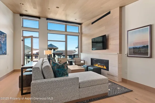 a living room with furniture a flat screen tv and a fireplace