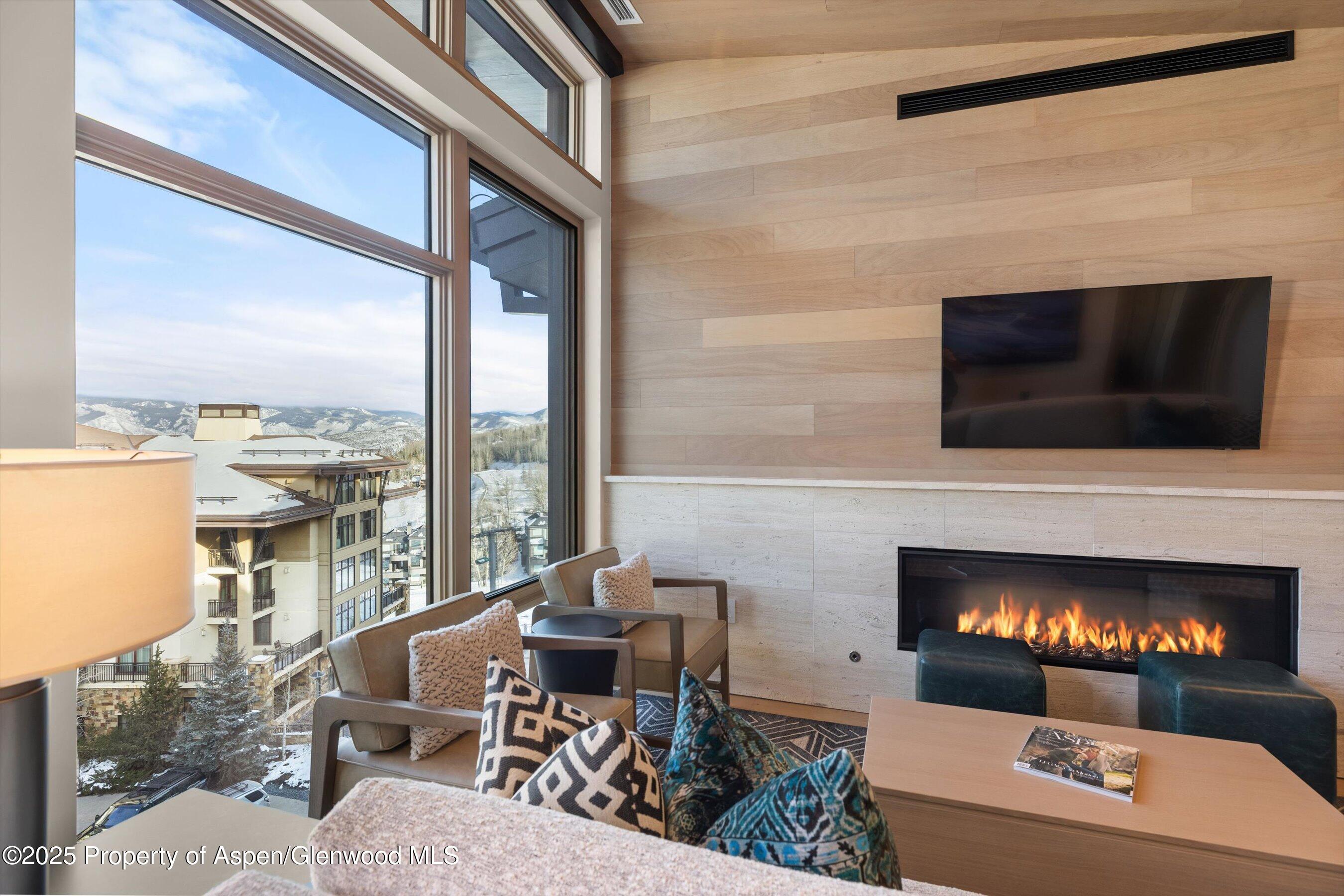 130 Wood Road, Unit 660662 Snowmass Village, CO 81615 - Photo 25 of 31 a living room with furniture a fireplace and a flat screen tv