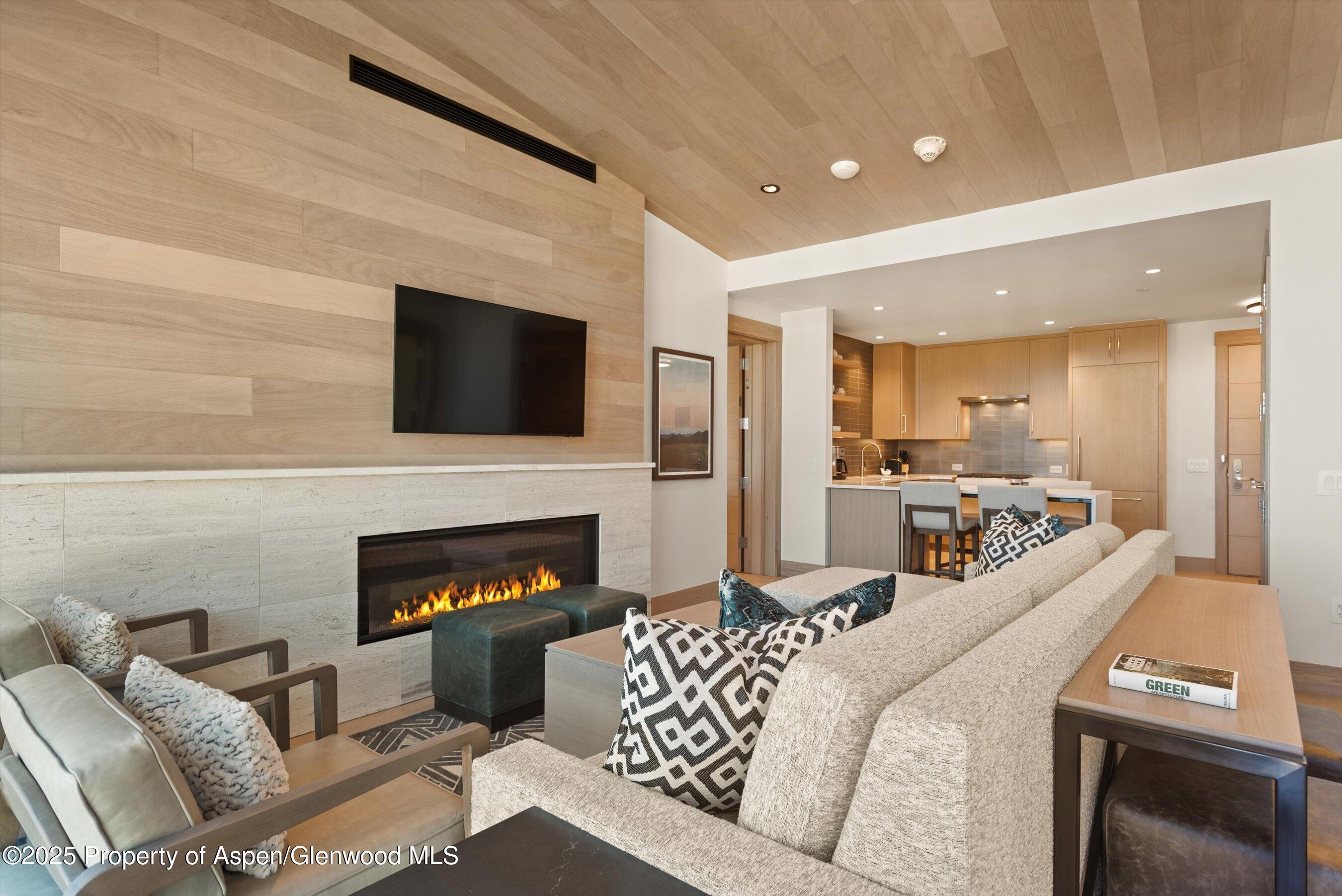 130 Wood Road, Unit 660662 Snowmass Village, CO 81615 - Photo 6 of 31 a living room with furniture a fireplace and a flat screen tv