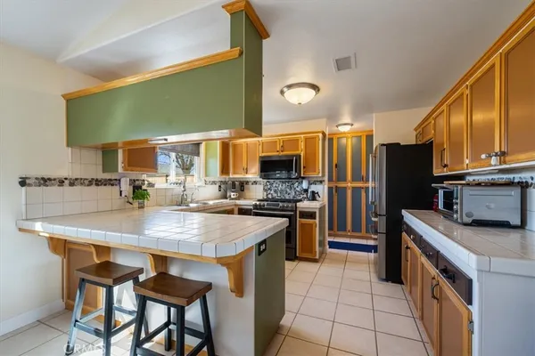 a kitchen with stainless steel appliances granite countertop a refrigerator stove and sink