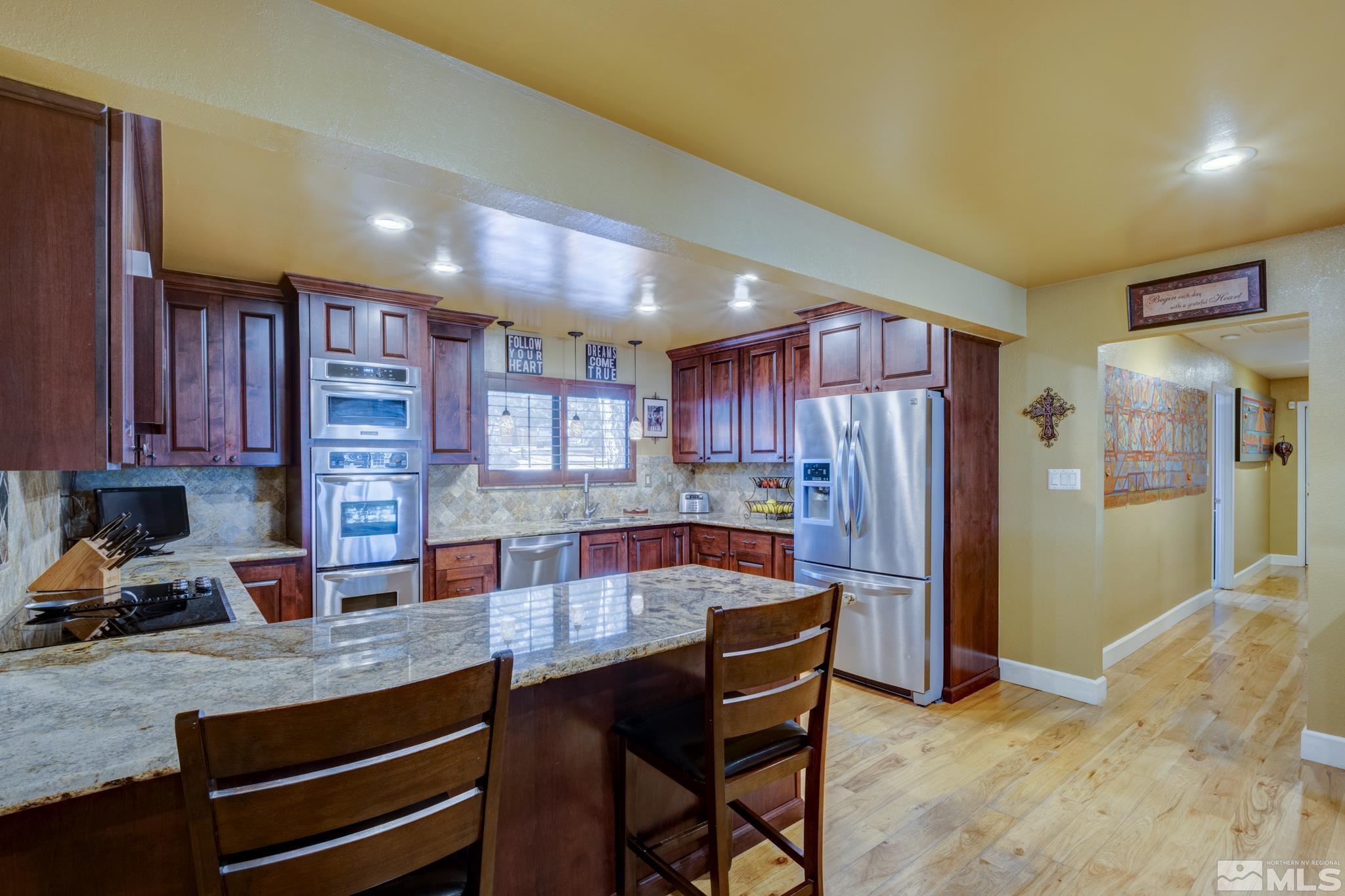 4185 Juniper Creek Road Reno, NV 89519 - Photo 5 of 40 a kitchen with stainless steel appliances granite countertop a refrigerator and a sink