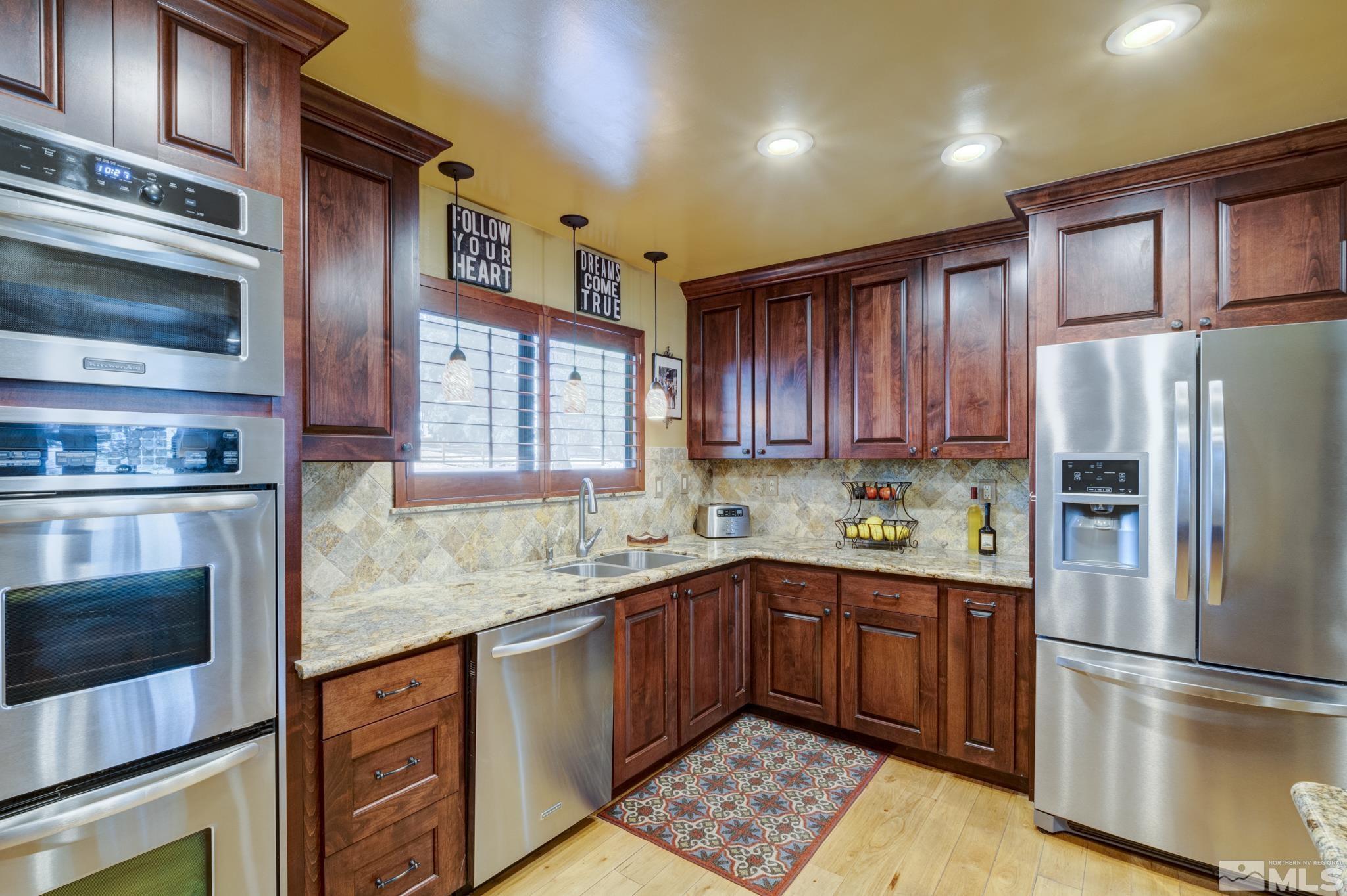 4185 Juniper Creek Road Reno, NV 89519 - Photo 8 of 40 a kitchen with stainless steel appliances granite countertop a refrigerator sink and cabinets
