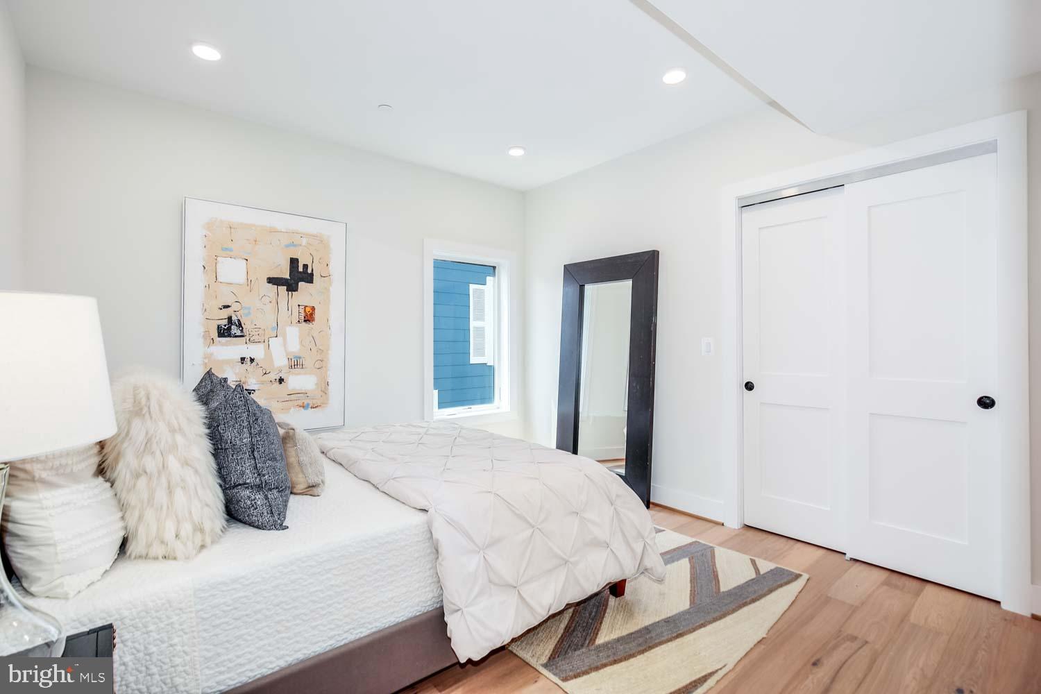1818 Rhode Island Avenue Northeast, Unit 4 Washington, DC 20018 - Photo 9 of 15 a bedroom with a large bed and wooden floor