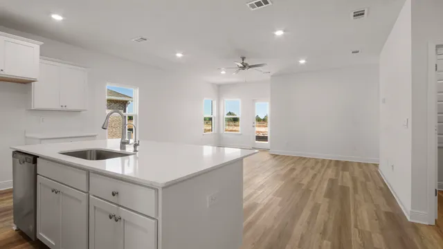 a kitchen with white cabinets and appliances