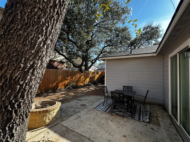 a backyard of a house with table and chairs