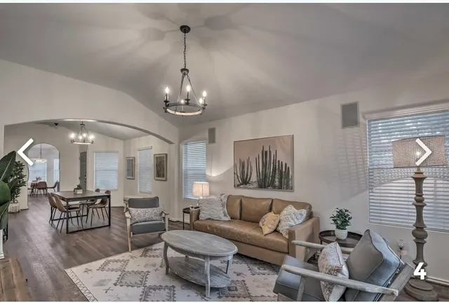 a living room with furniture and a chandelier