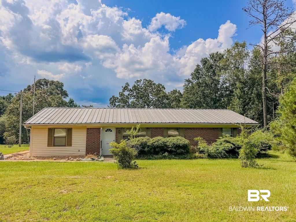 1456 Allen Walker Road Grove Hill, AL 36451 - Photo 1 of 28 Ranch-style home with a front lawn, brick siding, and a metal roof
