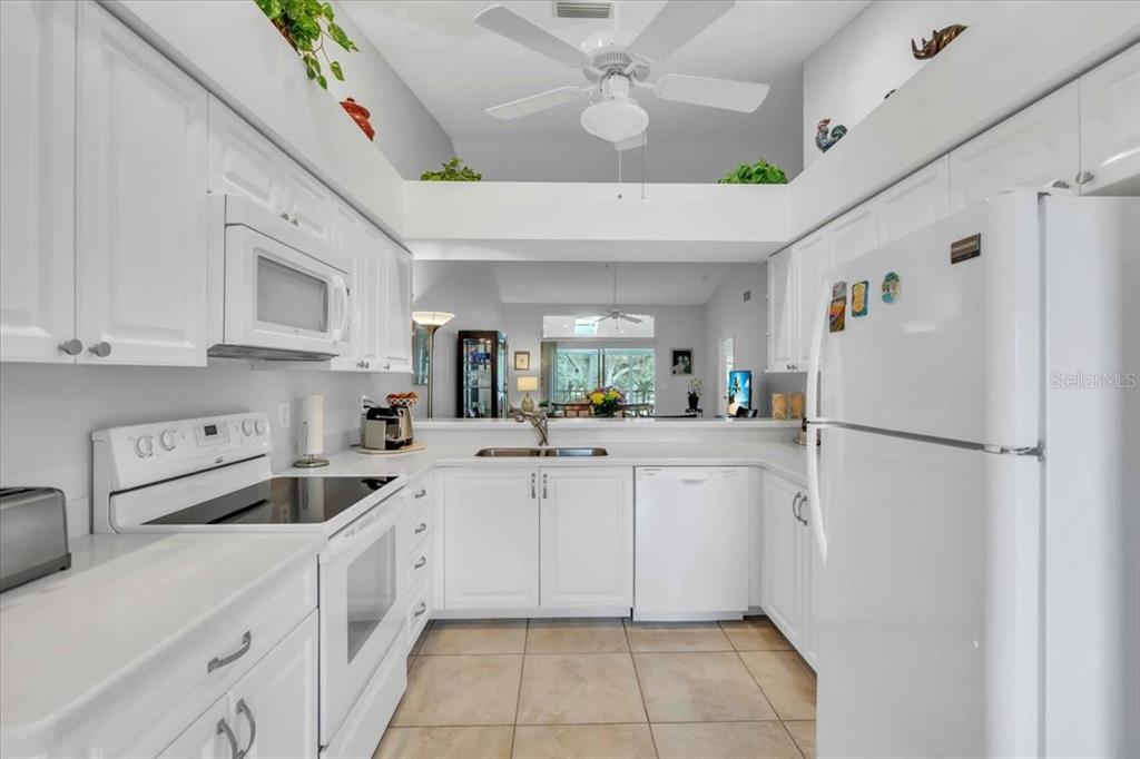 6807 Stone River Road, Unit 204 Bradenton, FL 34203 - Photo 6 of 54 a kitchen with white cabinets and white appliances