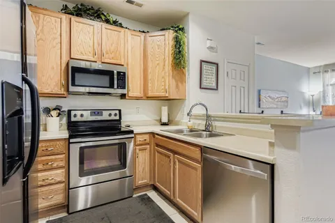 a kitchen with stainless steel appliances granite countertop a sink stove and microwave