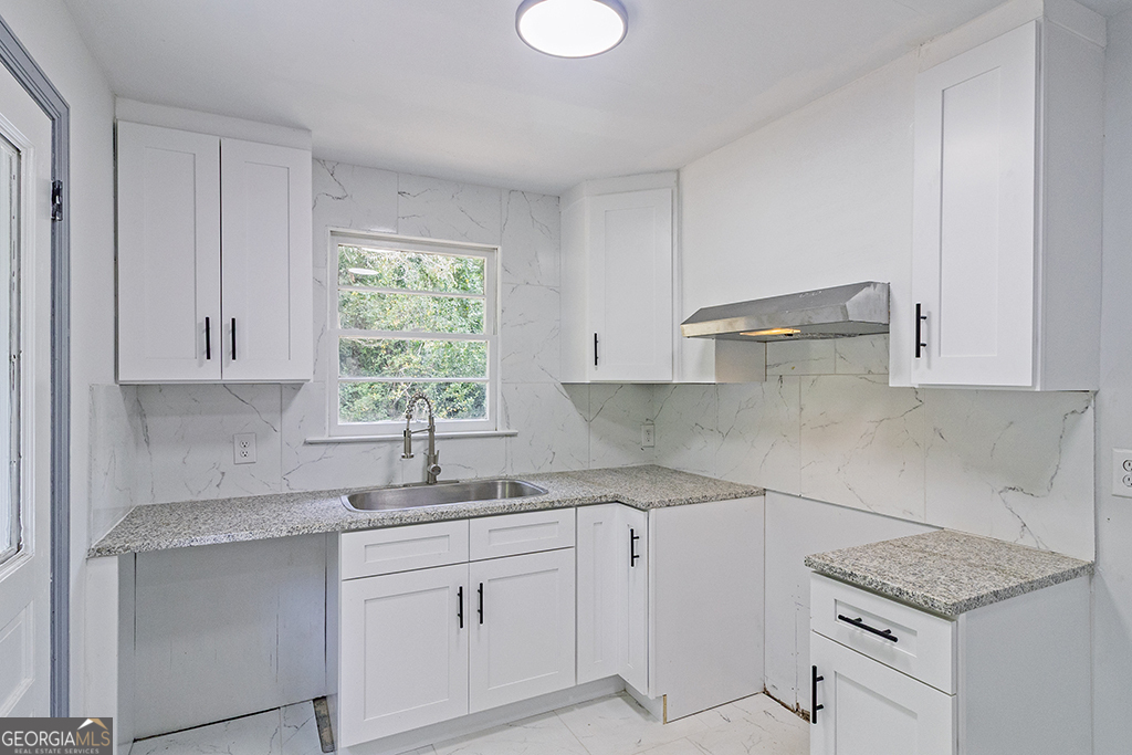 1124 North Beddingfield Drive Macon, GA 31206 - Photo 10 of 34 a kitchen with granite countertop white cabinets white appliances and a sink