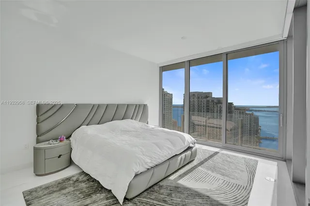 a living room with furniture large windows and floor to ceiling window