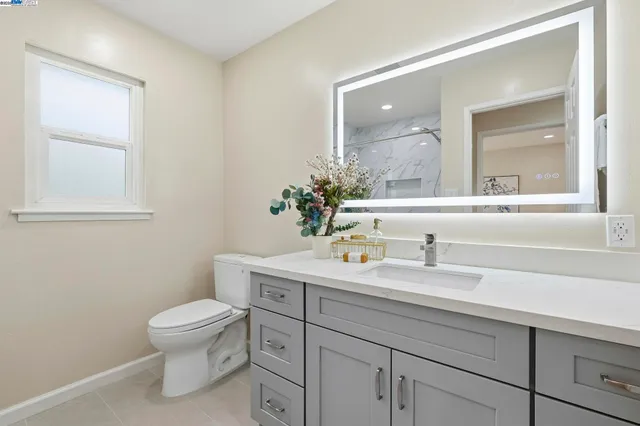 a bathroom with a sink a toilet and a mirror