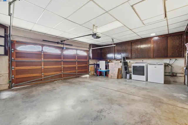a view of a backyard with a large tree and wooden fence