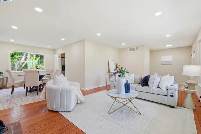a living room with furniture and a wooden floor