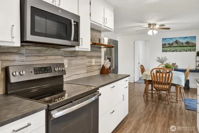 a kitchen with a stove a microwave and wooden floor