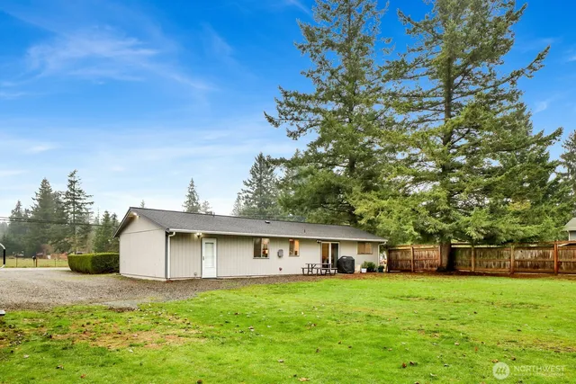 a front view of a house with a yard and trees