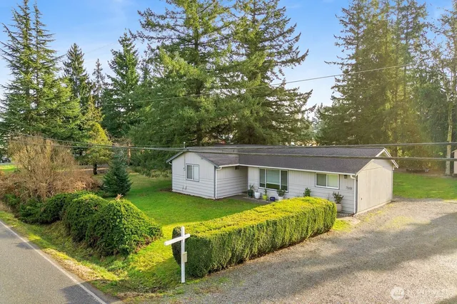 a view of a house with a big yard and large tree