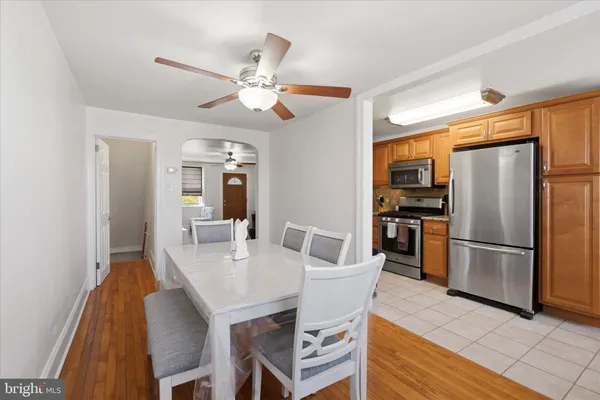 a kitchen with stainless steel appliances a refrigerator a sink a stove a dining table and chairs