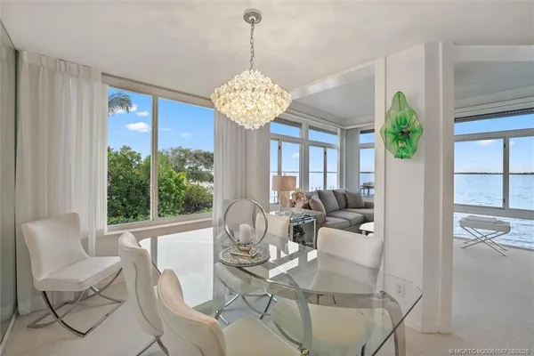 a dining room with furniture a chandelier and wooden floor