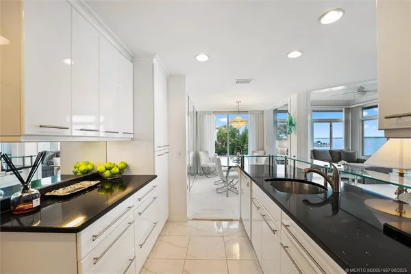 a large kitchen with stainless steel appliances granite countertop a sink and cabinets
