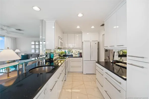 a large kitchen with granite countertop a large counter top stainless steel appliances and cabinets