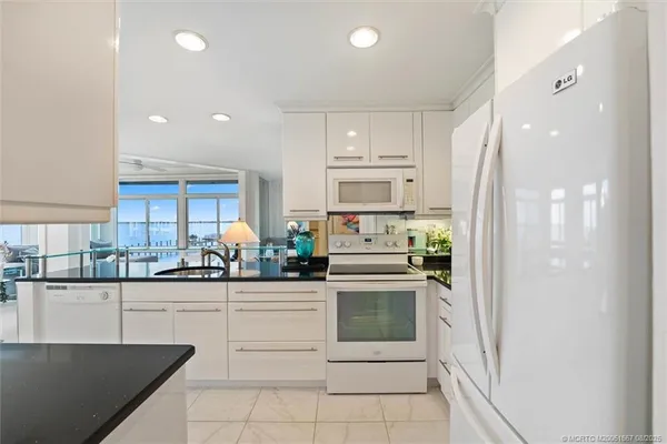 a kitchen with white cabinets and appliances