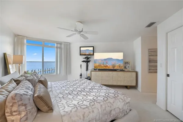 a bedroom with a bed and a large mirror on dresser