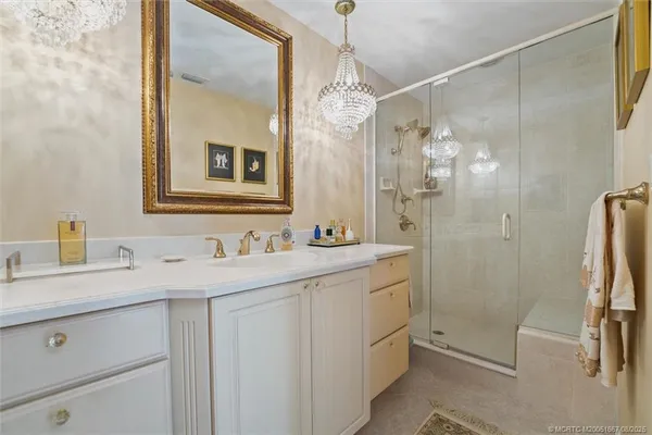 a bathroom with a double vanity sink mirror and shower