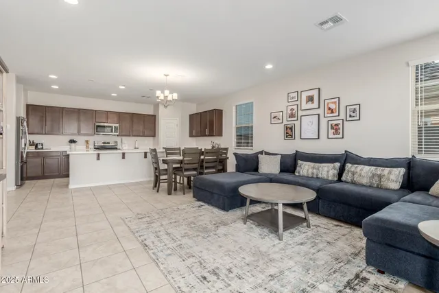 a large white kitchen with cabinets chairs and stainless steel appliances