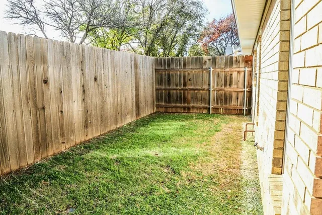 a view of a backyard with potted plants and wooden fence