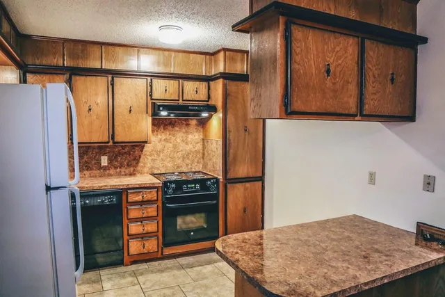 a kitchen with a stove and a wooden cabinets
