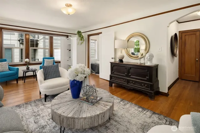 a living room with furniture a rug a fireplace and a floor to ceiling window