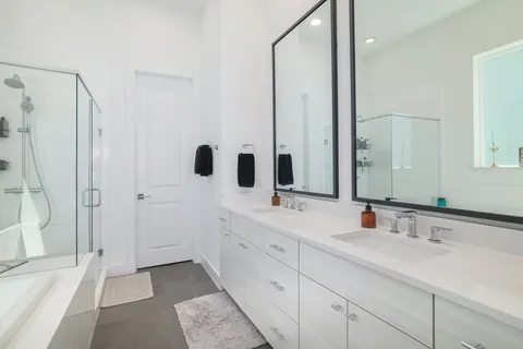 a bathroom with a double vanity sink mirror double and shower