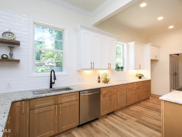 a large kitchen with kitchen island granite countertop a sink stainless steel appliances and cabinets