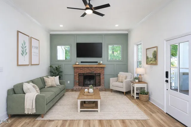 a living room with furniture a flat screen tv and a fireplace
