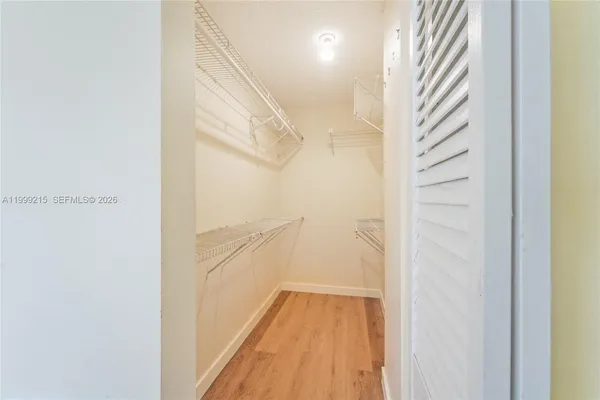 a view of a hallway with wooden floor and entryway
