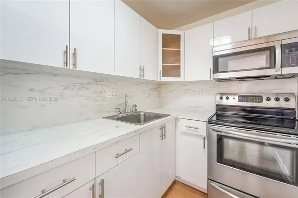 a kitchen with a sink stove and microwave