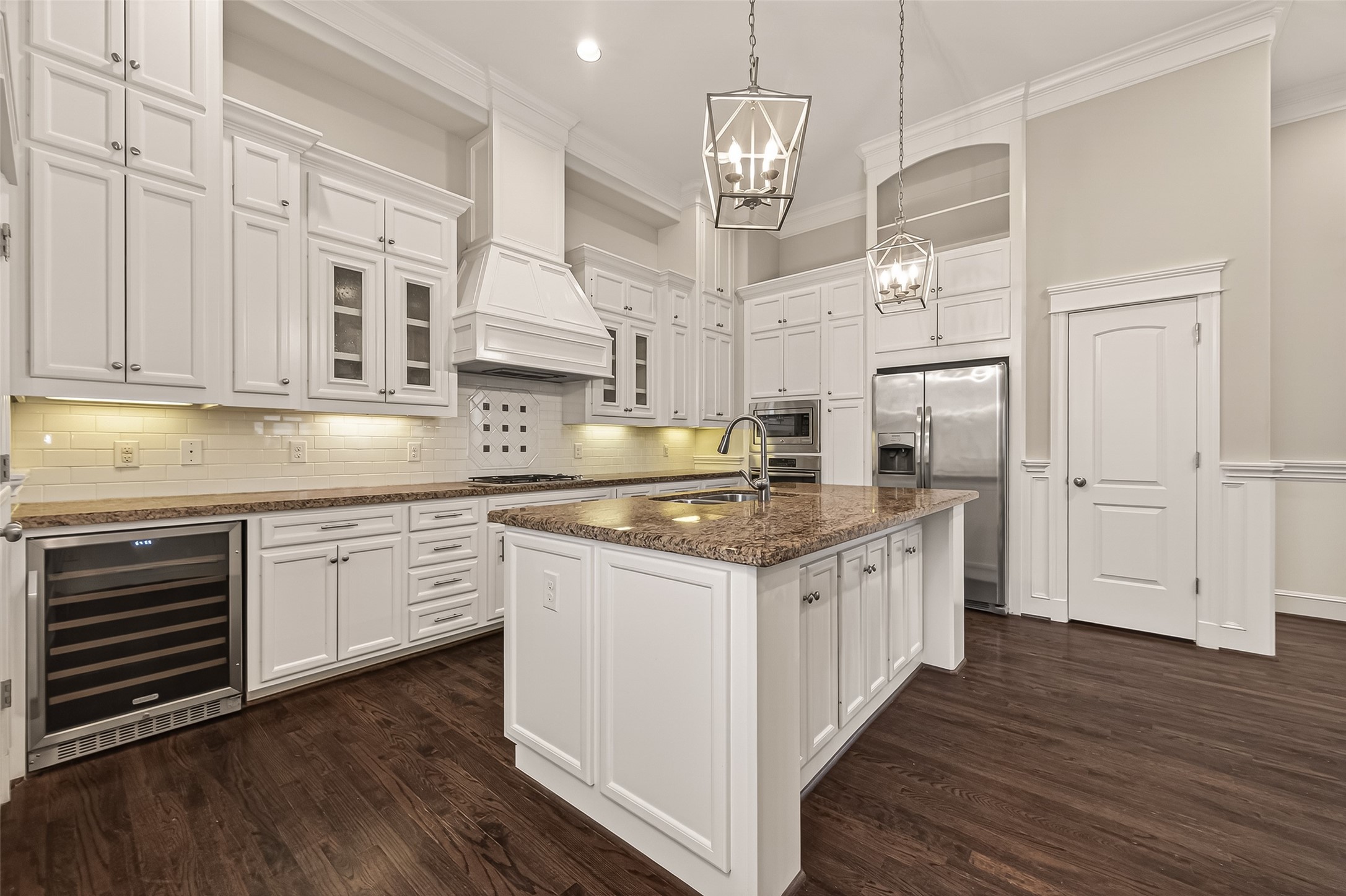 1431 West 25th Street Houston, TX 77008 - Photo 12 of 43 a kitchen with stainless steel appliances granite countertop wooden floors and white cabinets