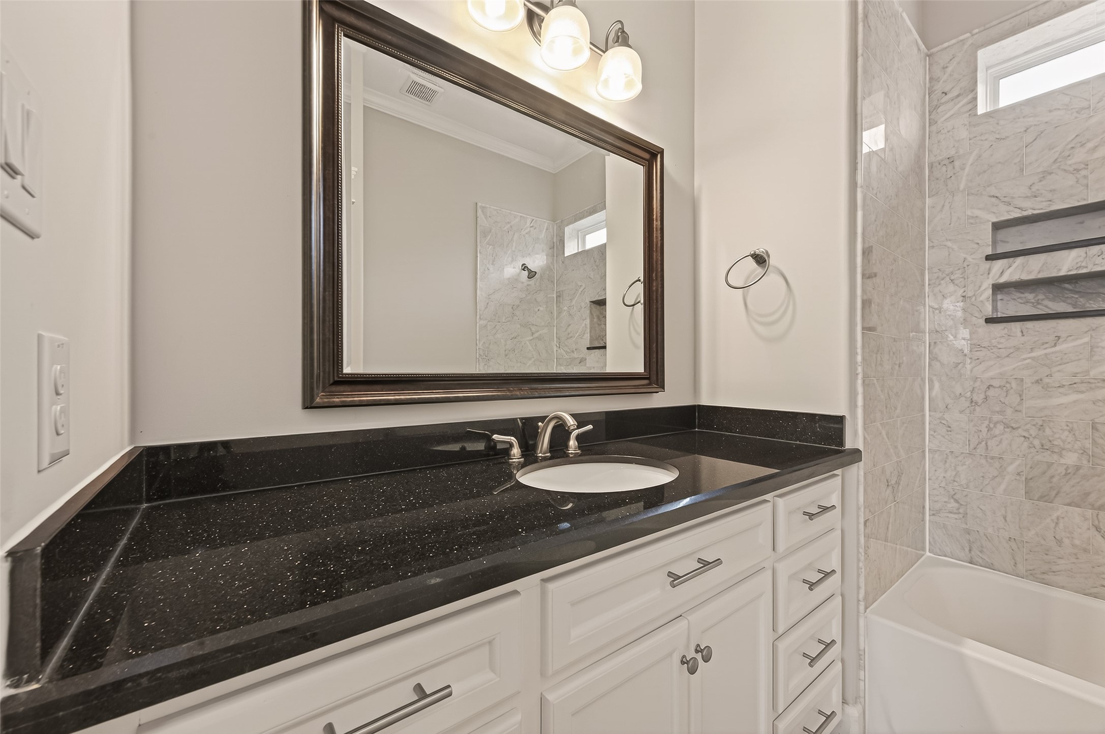 1431 West 25th Street Houston, TX 77008 - Photo 31 of 43 a bathroom with a granite countertop sink a mirror and a bathtub