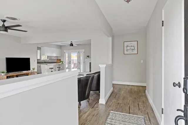 a living room with stainless steel appliances furniture and a flat screen tv