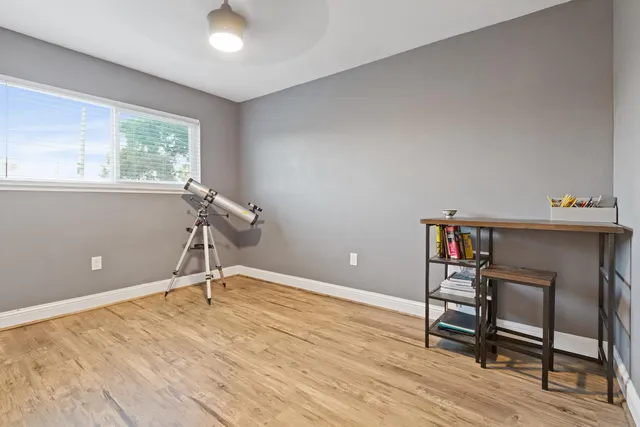 a view of a workspace with furniture and a window