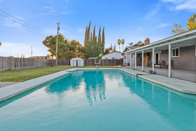 a view of a house with pool and a yard