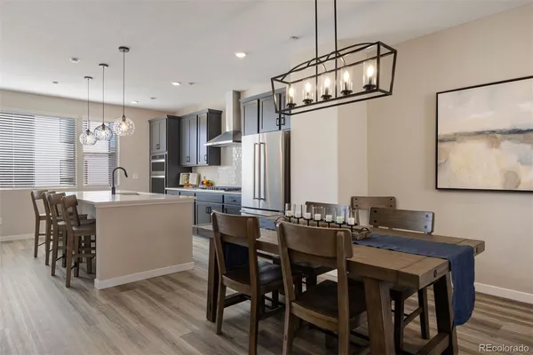 a kitchen with a dining table chairs cabinets and stainless steel appliances